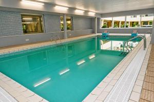 a swimming pool with blue water in a building at Caribean Style in Middelkerke