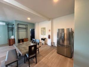a kitchen with a table and a stainless steel refrigerator at Apartment with Pool & Gym in Querétaro