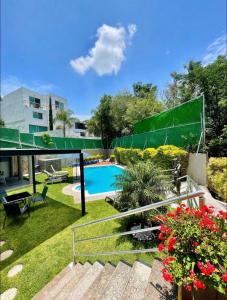 a backyard with a swimming pool and flowers at Apartment with Pool & Gym in Querétaro