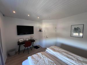 a bedroom with a bed and a desk with a television at Arctic hostel in Qaqortoq