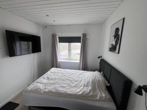 a small bedroom with a bed and a window at Arctic hostel in Qaqortoq