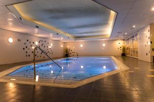 a large swimming pool in a building at Residence Terschelling Wellness Waddenresort in Midsland +26 photos