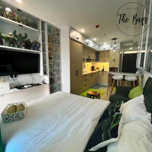 a bedroom with a large white bed and a kitchen at Marvel Fan Studio Condo with Pool CDO TheBaqs in Balulang