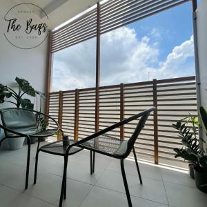 a chair and a table in front of a window at Marvel Fan Studio Condo with Pool CDO TheBaqs in Balulang