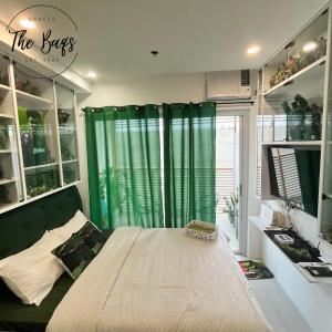 a bedroom with a bed with a green curtain at Marvel Fan Studio Condo with Pool CDO TheBaqs in Balulang