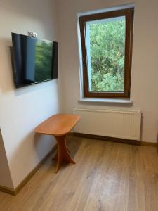 a room with a wooden table and a window at Hostel in Piotrków Trybunalski +17 photos
