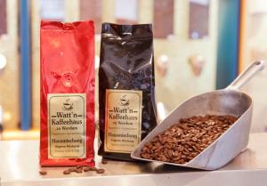 zwei Beutel Kaffee und eine Pfanne mit Kaffeebohnen in der Unterkunft Hotel Werdumer Hof in Werdum