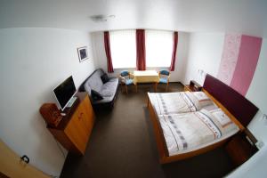 ein Hotelzimmer mit einem Bett und einer Couch in der Unterkunft Hotel Werdumer Hof in Werdum