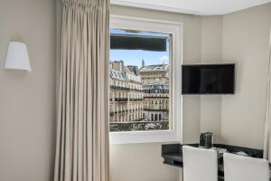 a room with a window with a view of the city at Excelsior Opera in Paris