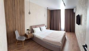 a bedroom with a bed and a chair in it at Family 30 in Lutsk