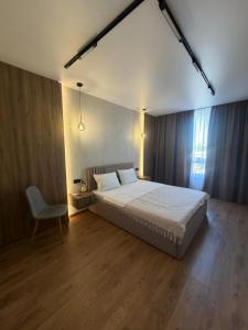 a bedroom with a large bed and a chair at Family 30 in Lutsk