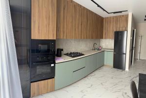 a kitchen with wooden cabinets and a black appliances at Family 30 in Lutsk