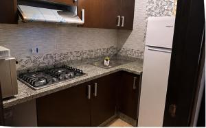 a kitchen with a stove and a sink and a refrigerator at cosy and comfortable stay in Oued Laou