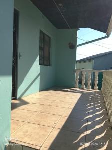 a balcony of a house with a shadow on the floor at LINGE'S LODGE EXTENSION in Lusikisiki