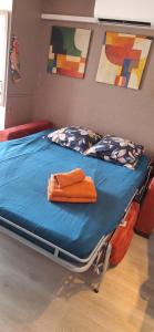 a bed with an orange towel on it in a room at Mimilou Eleuthera 300 m centre naturiste in Cap d'Agde