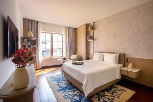 a hotel room with a bed and a vase of flowers at DLF Club 4 in Gurgaon +59 photos