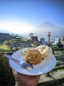 a person holding a plate with a dessert on it at villa cabin vianda in Kejajar +13 photos