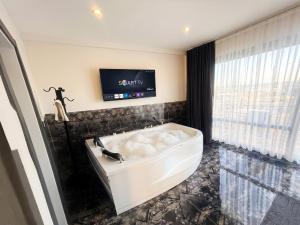 a bathroom with a bath tub and a tv at Kumkapı Hotel - Special Category in Istanbul +20 photos