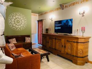 a living room with a flat screen tv and a couch at maison climatisée à thème médiéval avec baignoire balnéothérapie in Sens