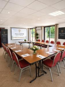 a conference room with a long table and chairs at Hôtel Le Palladior Voiron in Voiron