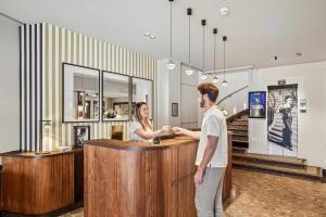 a man and a woman standing at a counter at Excelsior Opera in Paris