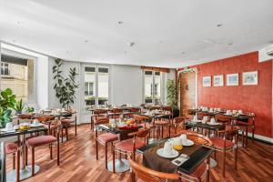 a restaurant with wooden tables and chairs and windows at Excelsior Opera in Paris