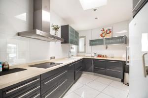 a kitchen with gray cabinets and a sink at Can Drago in Ibiza Town