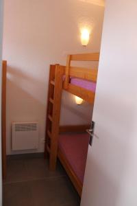Zimmer mit 2 Etagenbetten und einer Tür in der Unterkunft Appartement 239 Les Salicornes in Arles