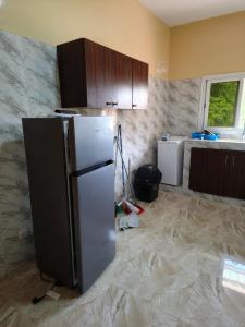 a kitchen being remodeled with a refrigerator and cabinets at Le Rivage de Sérénité in Sali Nianiaral
