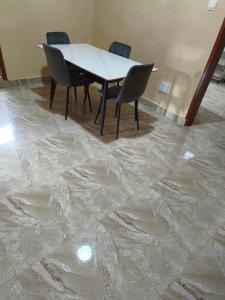 a table and chairs in a room with a marble floor at Le Rivage de Sérénité in Sali Nianiaral