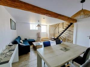 a living room with a table and a blue couch at Chambre d'hôte ColChris in Saint-Pierre-le-Vieux