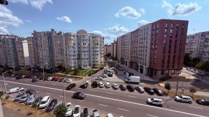a city street with parked cars and tall buildings at Apartment OneClickRent 16 in Chişinău