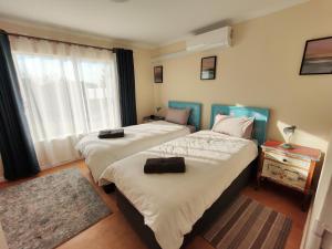 a hotel room with two beds and a window at Prince and Pooch Self Catering in Windhoek