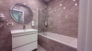 a bathroom with a tub and a sink and a mirror at Apartment OneClickRent 16 in Chişinău +33 photos