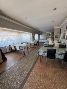 a dining room with tables and chairs and windows at Aslanlar Otel in Tekirdağ