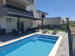 a swimming pool in the backyard of a house at Mima apartments in Povljana