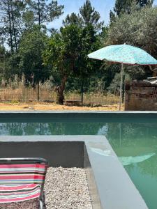 a chair and an umbrella next to a swimming pool at Quinta Chaouen in Mouronho