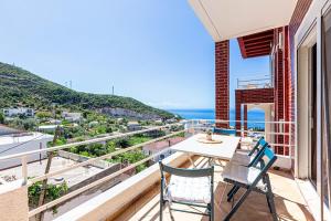 a balcony with a table and chairs and the ocean at Dhermi's Icon Big 1BR Apt 10 in Dhërmi