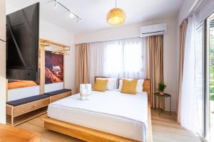 a bedroom with a large white bed and a flat screen tv at Dhermi's Icon Big 1BR Apt 10 in Dhërmi