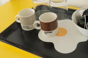 two coffee mugs sitting on a glass tray at VItruVIo POP in Fano