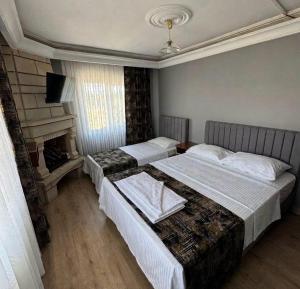 a hotel room with two beds and a fireplace at Aslanlar Otel in Tekirdağ