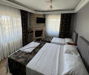 a hotel room with two beds and a television at Aslanlar Otel in Tekirdağ