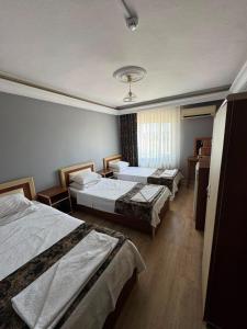 a hotel room with two beds and a window at Aslanlar Otel in Tekirdağ