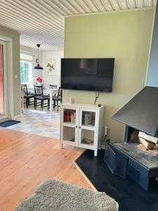 a living room with a fireplace and a flat screen tv at Hus Bjöksjöblick in Hällefors