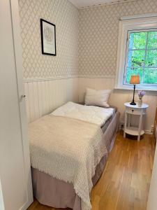 a small bedroom with a bed and a window at Hus Bjöksjöblick in Hällefors