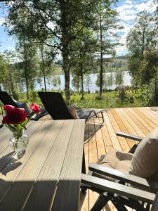a wooden deck with a table with a laptop on it at Hus Bjöksjöblick in Hällefors