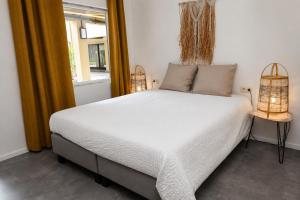 a bedroom with a large white bed with a window at BEACH house in Westende-Bad +31 photos