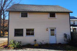 a small white house with a white door at Shelburne Falls on Main in Shelburne +6 photos