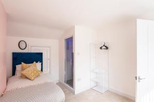 a bedroom with a bed with a blue headboard at Spacious 3BR Family Home with Big Garden in Manchester +15 photos