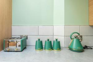 a kitchen with three teapots and a toaster at Spacious 3BR Family Home with Big Garden in Manchester